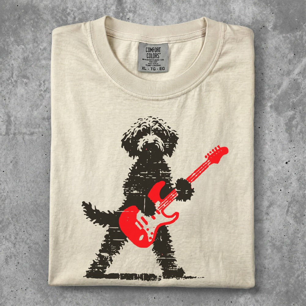 Black dog with red electric guitar graphic on a cream t-shirt.