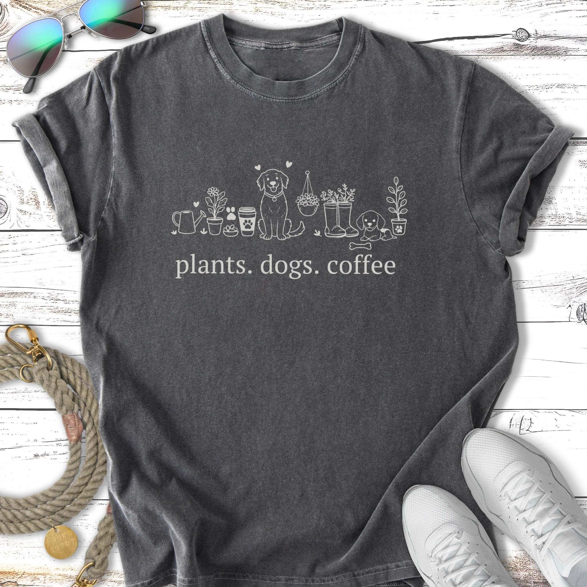 T-shirt with white line art of plants, dogs, and the text "plants. dogs. coffee."