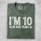 Green t-shirt with "I'm 10 in dog years" graphic.