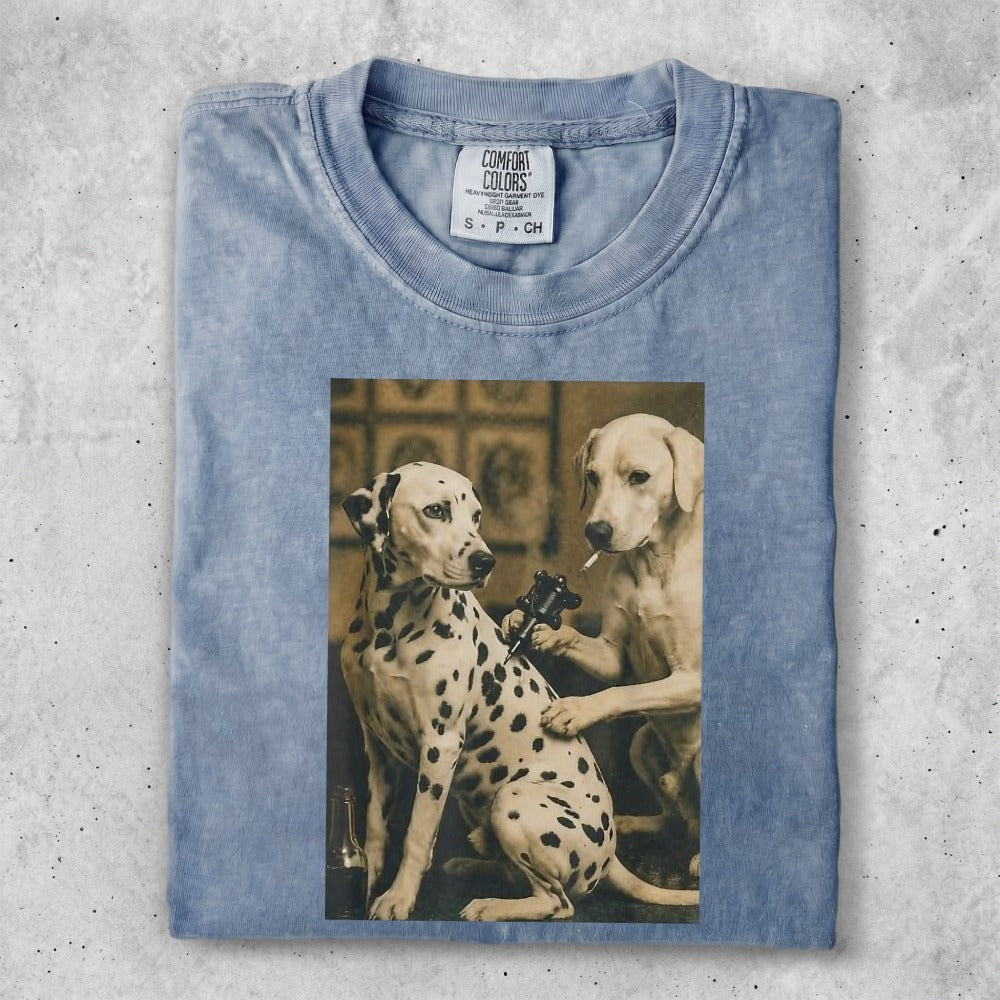 Dalmatian and yellow lab dog receiving tattoos on a faded blue t-shirt.
