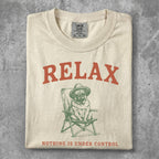 Cream t-shirt with pug wearing hat in chair, "RELAX" and "NOTHING IS UNDER CONTROL" text.
