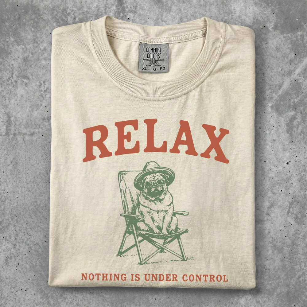 Cream t-shirt with pug wearing hat in chair, "RELAX" and "NOTHING IS UNDER CONTROL" text.