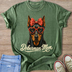 Green t-shirt with Doberman dog wearing heart glasses and polka dot bow.
