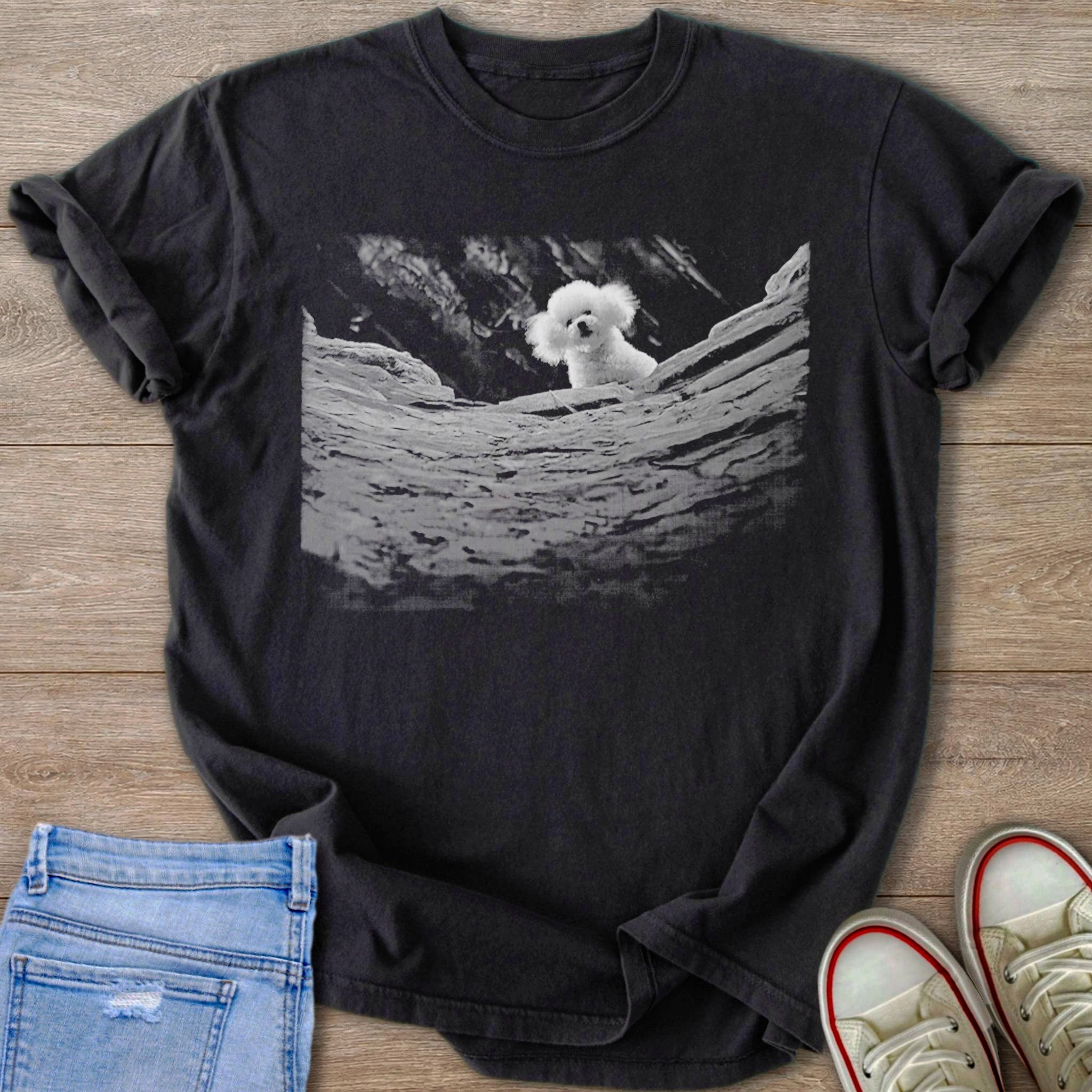 Black Comfort Colors 1717 t-shirt with a grayscale print of a fluffy white dog from silence of the lambs peeking from behind rocks.