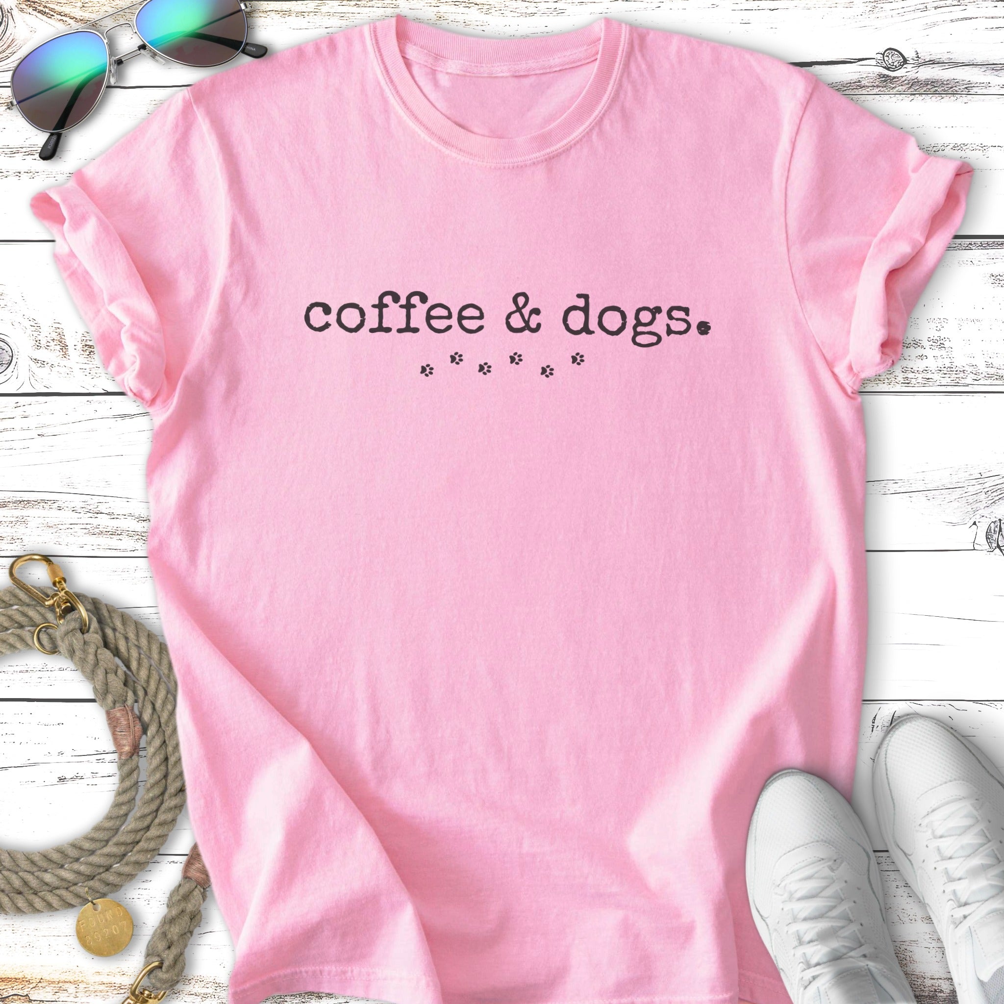 Pink t-shirt with "coffee & dogs" text and paw print graphic.