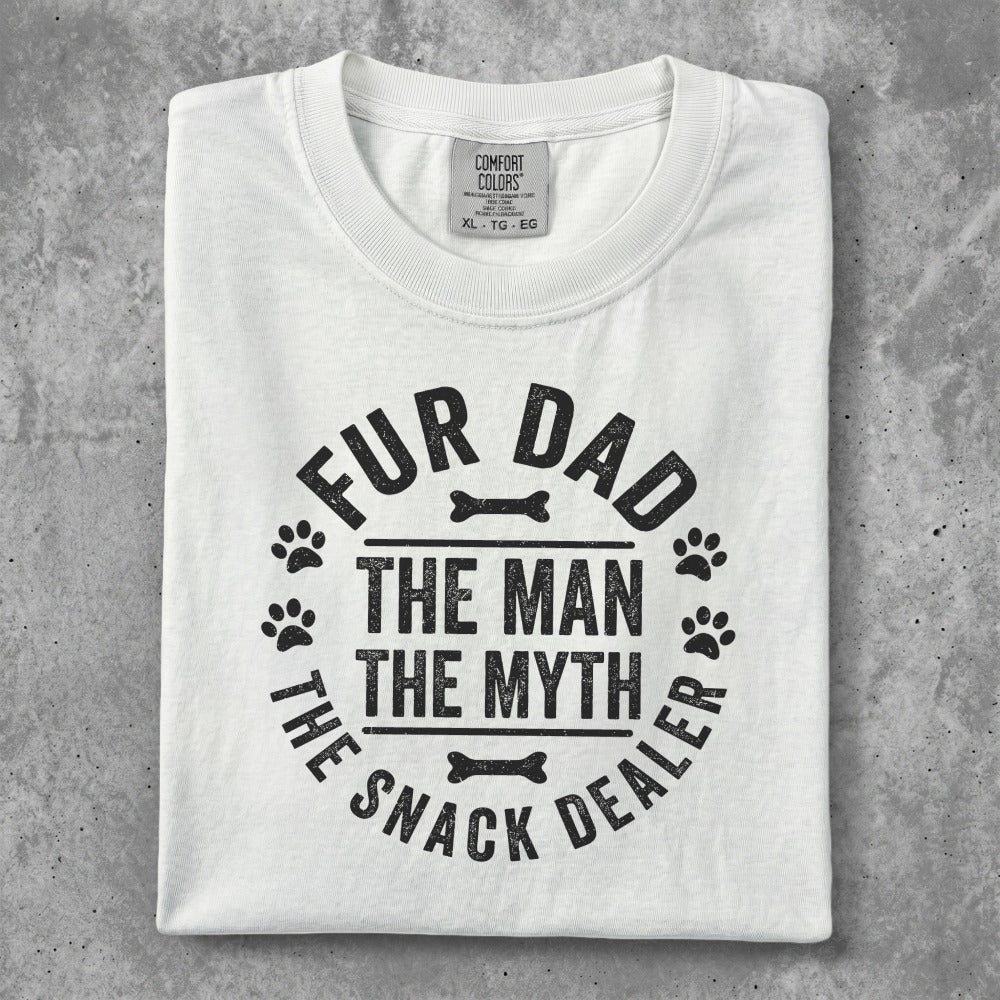 White t-shirt with "Fur Dad The Man The Myth The Snack Dealer" text and paw prints.