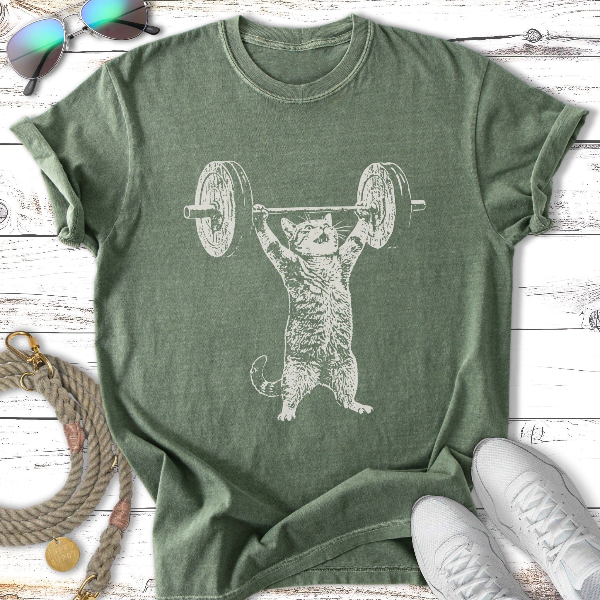 Cat lifting a barbell on a distressed green t-shirt.