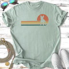 French bulldog silhouette against a retro sunset graphic on a light green t-shirt.
