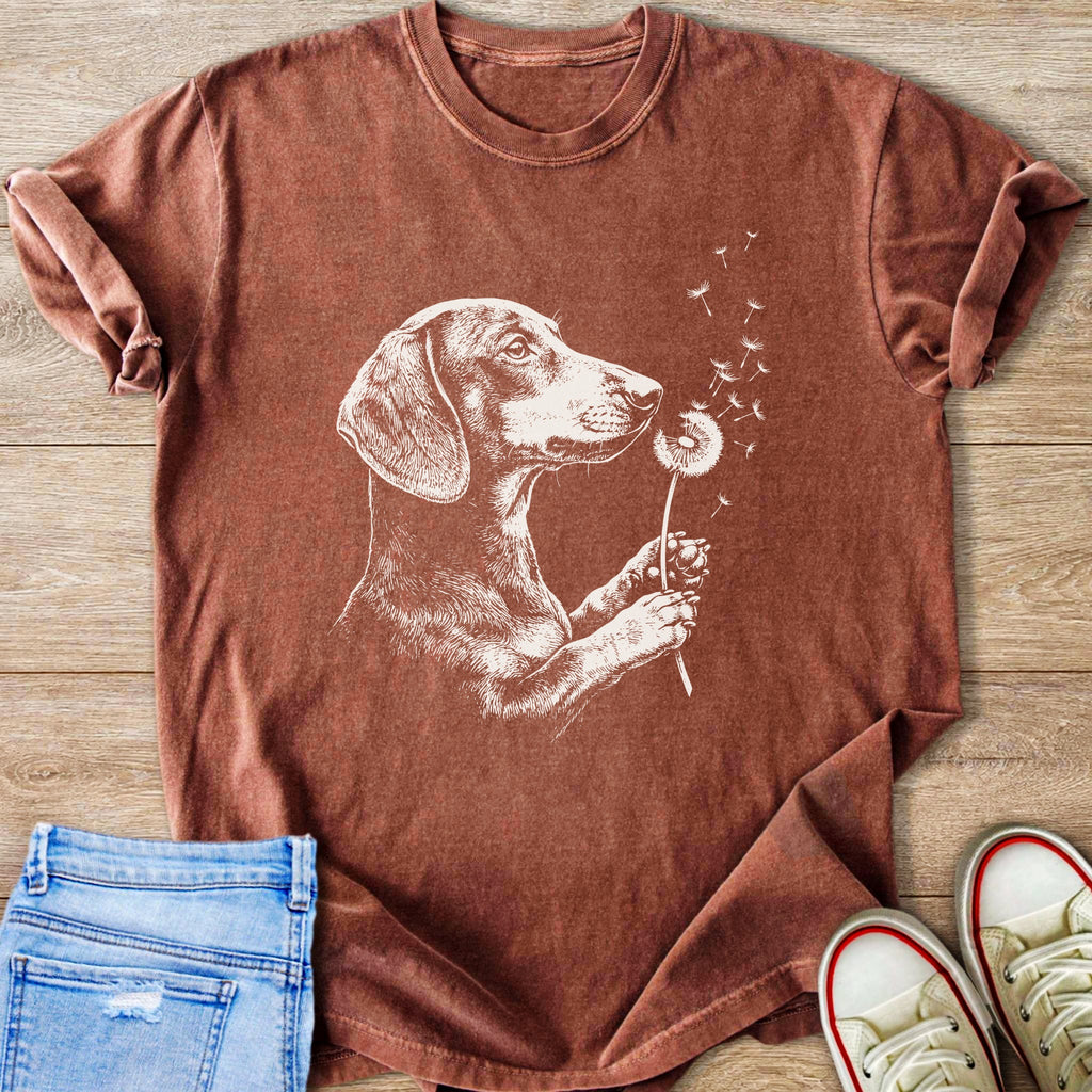 Brown t-shirt with a white line drawing of a dachshund holding a dandelion.