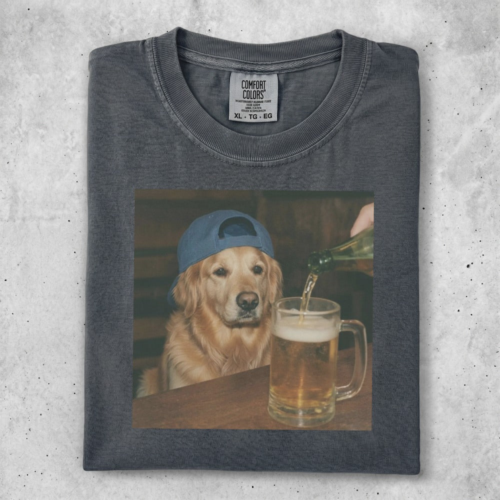 Golden retriever in blue hat drinks beer from mug on table.