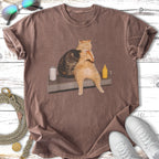 Two cats share a hot dog on a table, with a soda can and mustard bottle nearby.