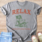 Gray t-shirt with distressed graphic of a dog in a recliner, wearing a cowboy hat. Text reads "RELAX NOTHING IS UNDER CONTROL".