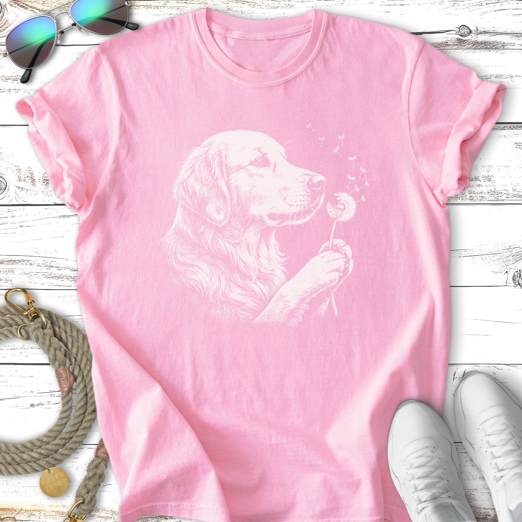 Pink t-shirt with a line drawing of a golden retriever blowing a dandelion.