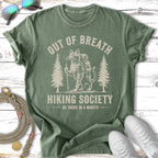 Green t-shirt with distressed cat hiking graphic and text.