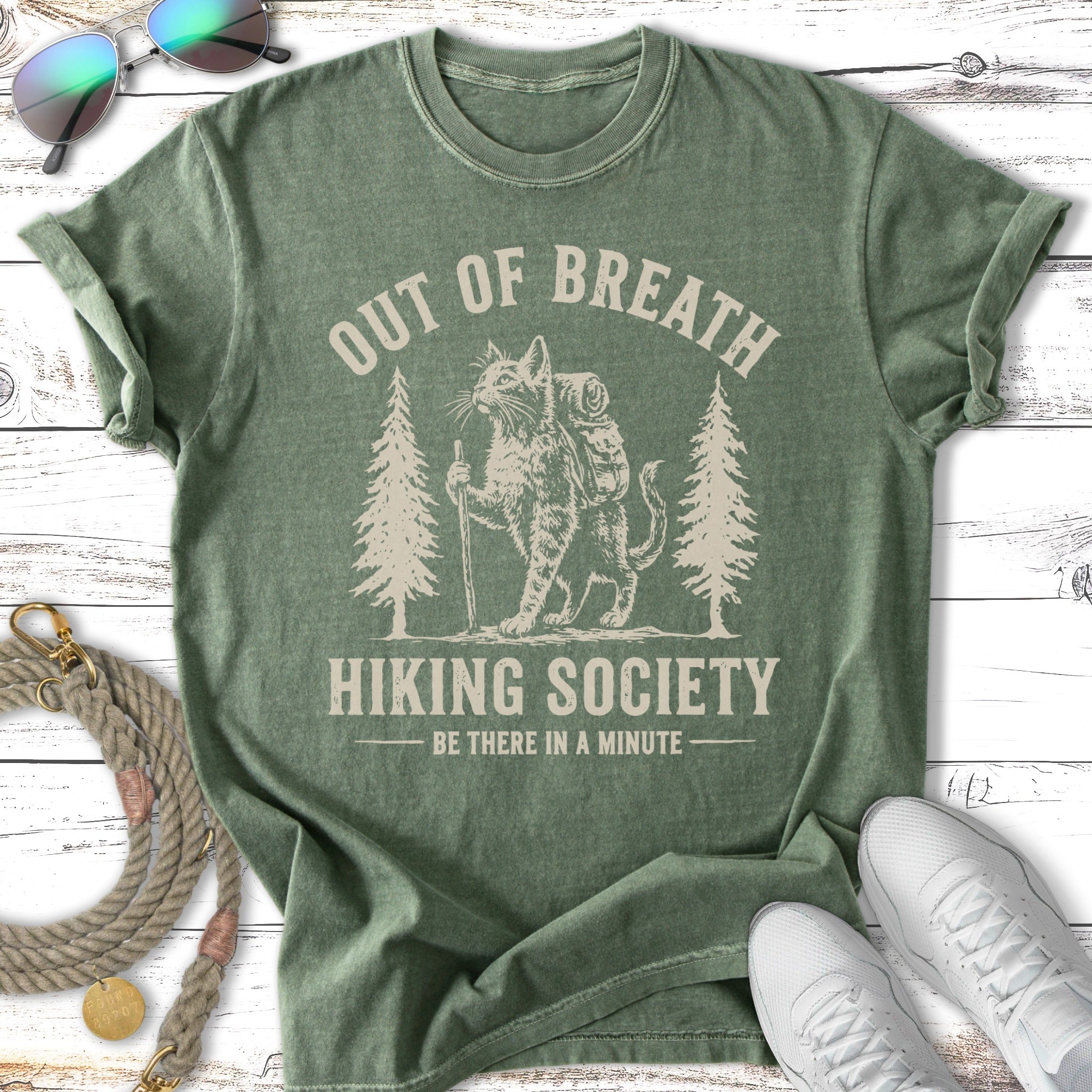 Green t-shirt with distressed cat hiking graphic and text.