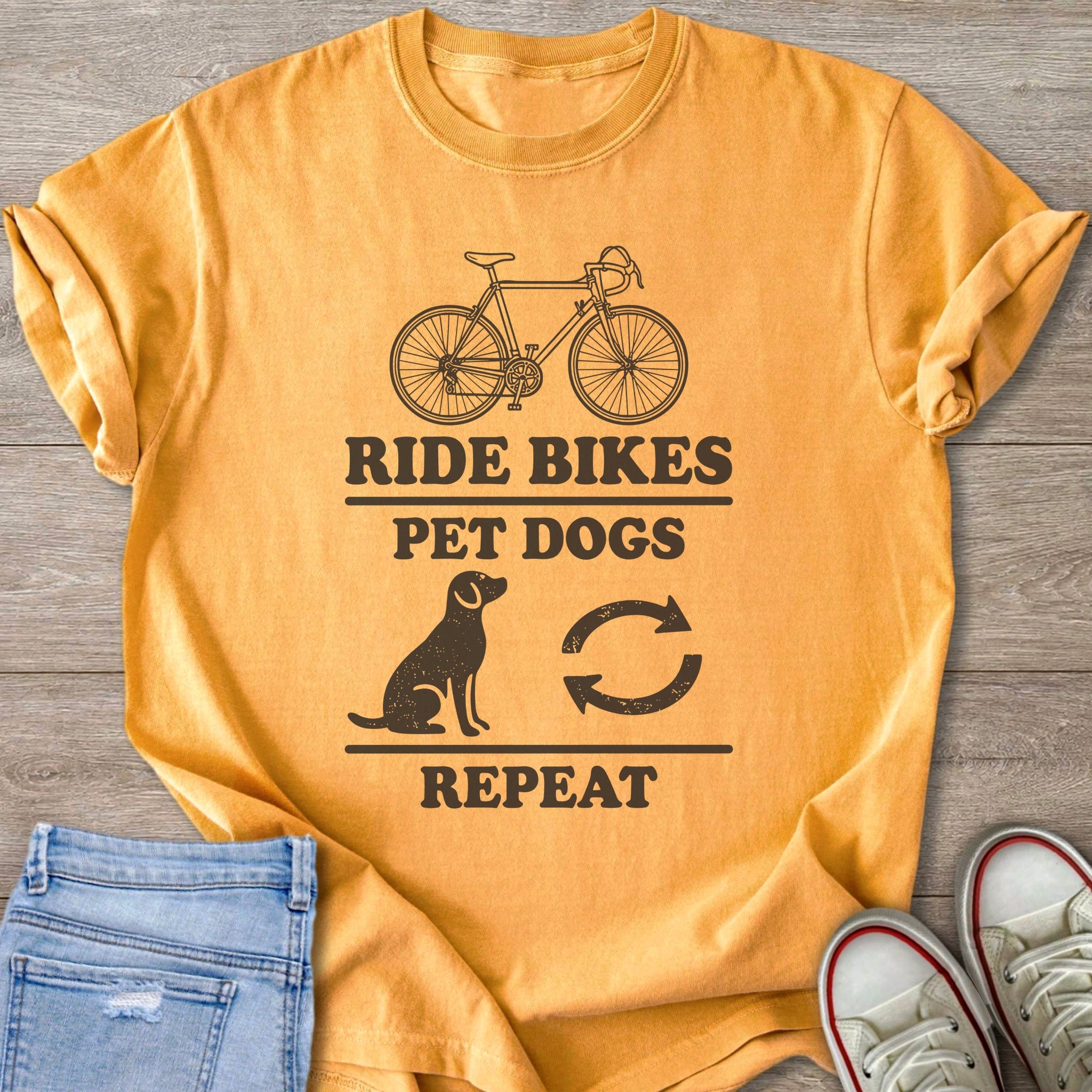 Yellow t-shirt with black graphic: "Ride Bikes Pet Dogs Repeat".