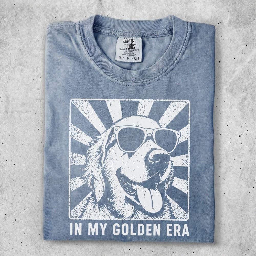 Blue t-shirt with a graphic of a golden retriever wearing sunglasses and text "IN MY GOLDEN ERA".