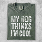 Green t-shirt with distressed white text reading "MY DOG THINKS I'M COOL."