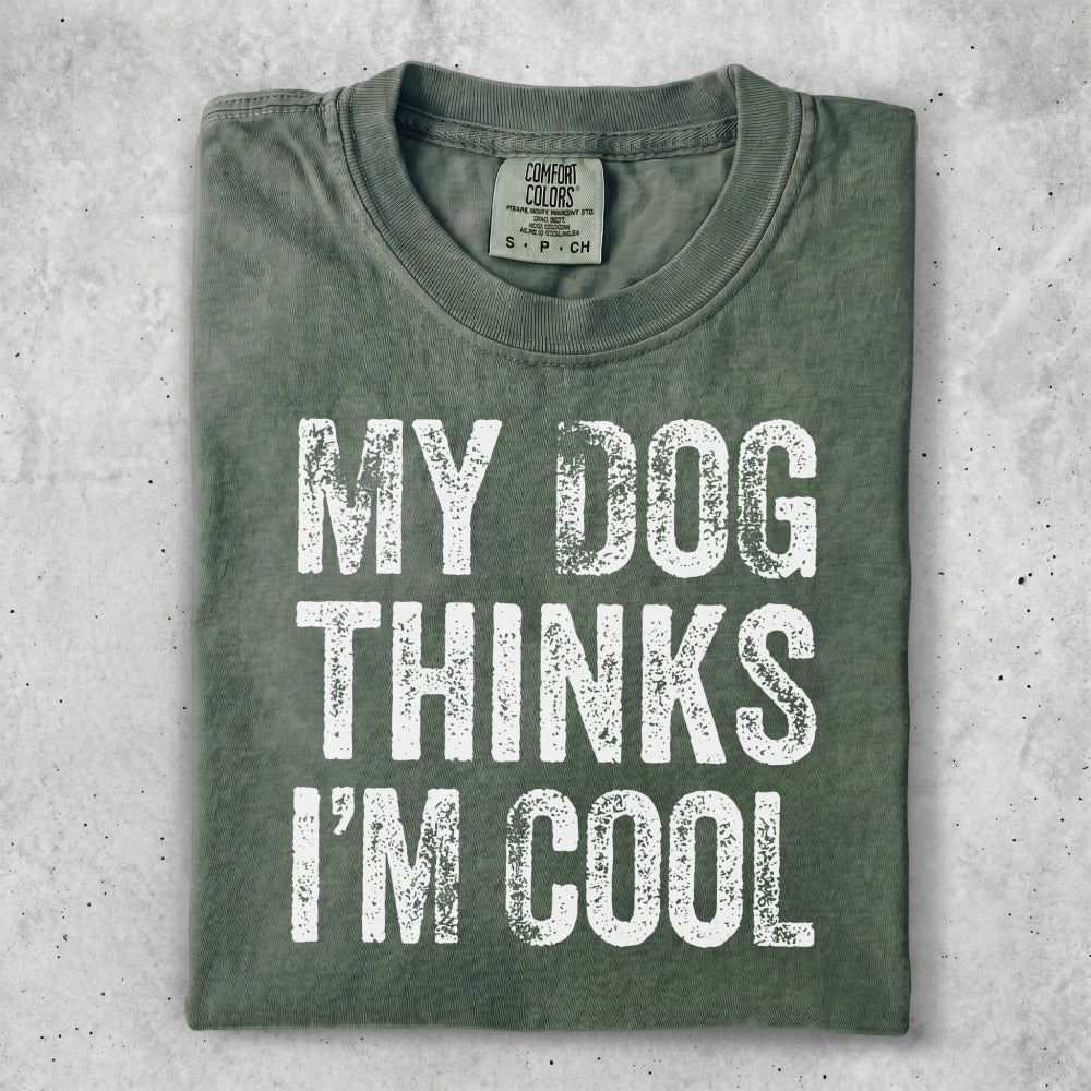 Green t-shirt with distressed white text reading "MY DOG THINKS I'M COOL."