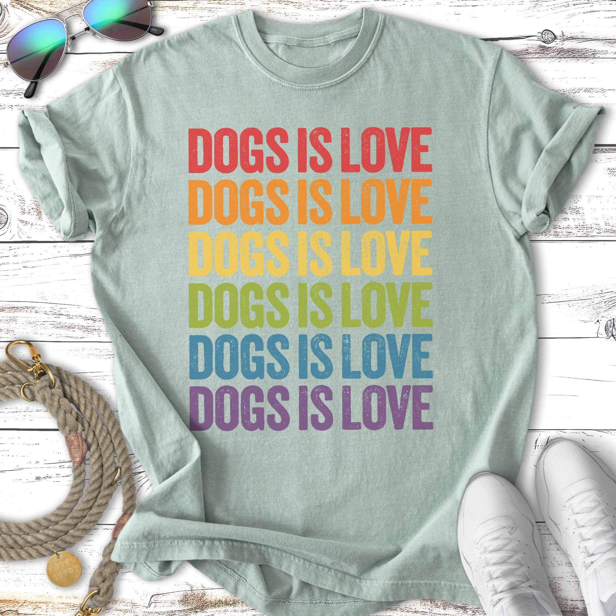 T-shirt with rainbow text "DOGS IS LOVE" repeated six times.