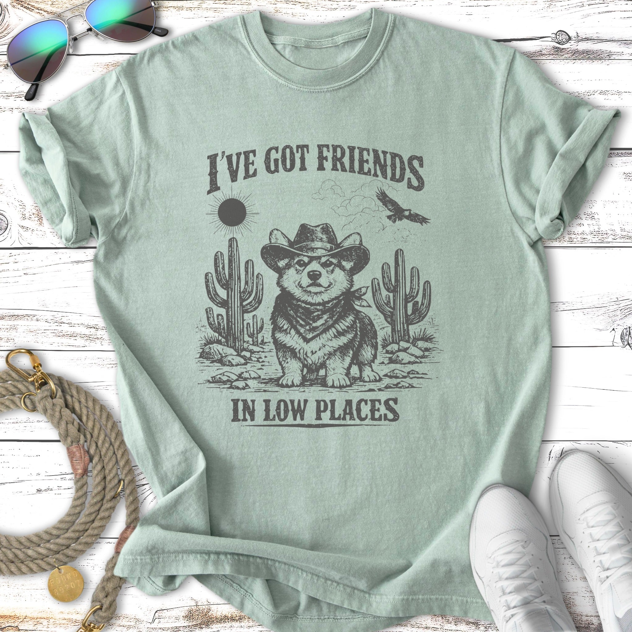 Corgi in cowboy hat with cacti and text "I'VE GOT FRIENDS IN LOW PLACES".