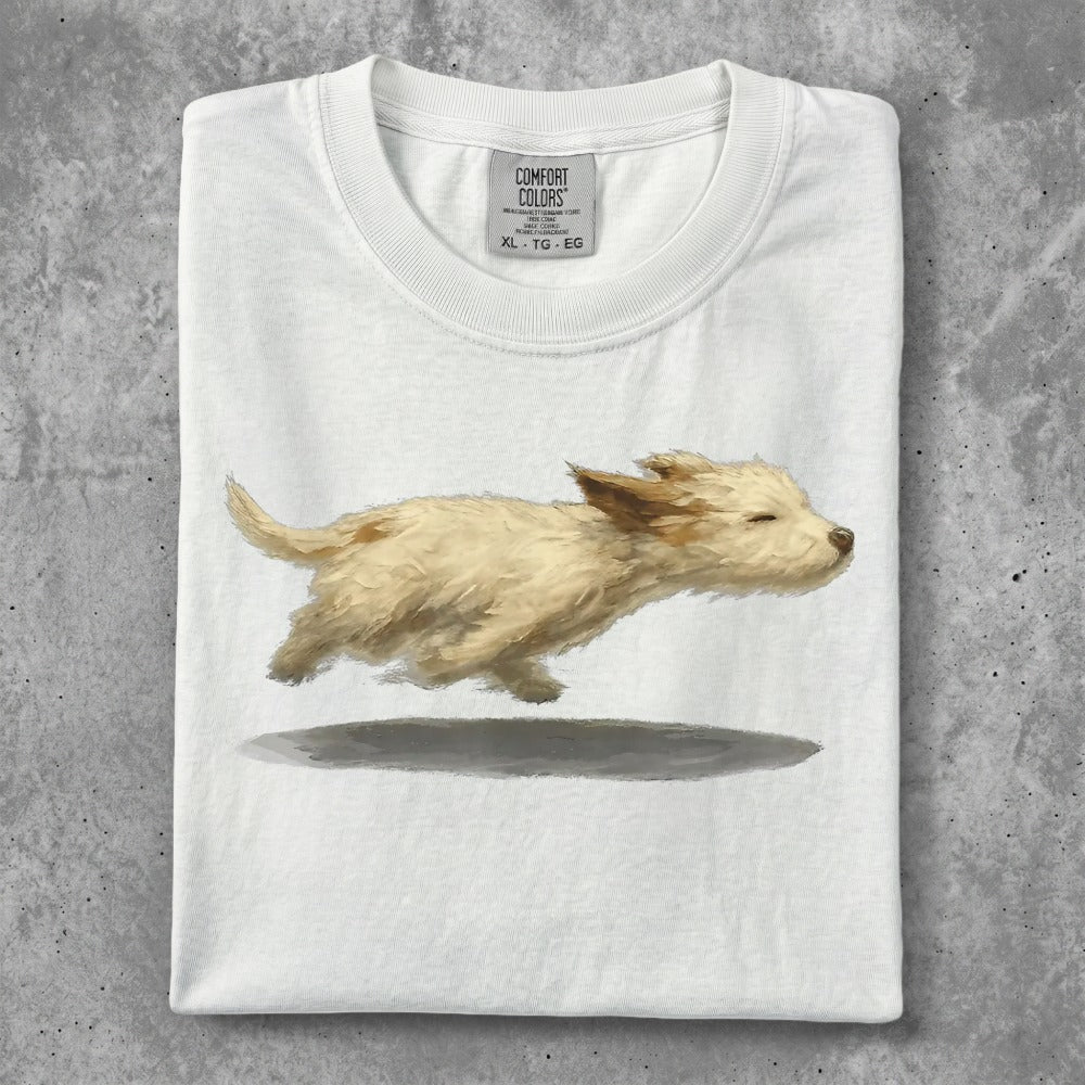 White t-shirt featuring a painted illustration of a running golden puppy.