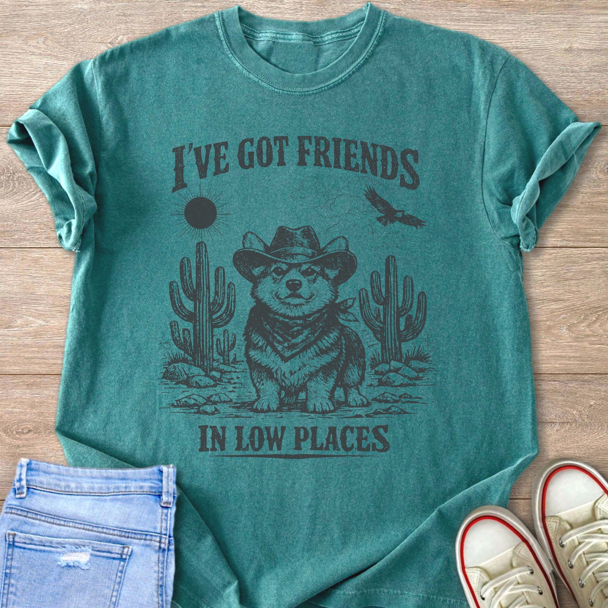 Teal t-shirt with a Corgi wearing a cowboy hat and bandana, and text "I'VE GOT FRIENDS IN LOW PLACES".