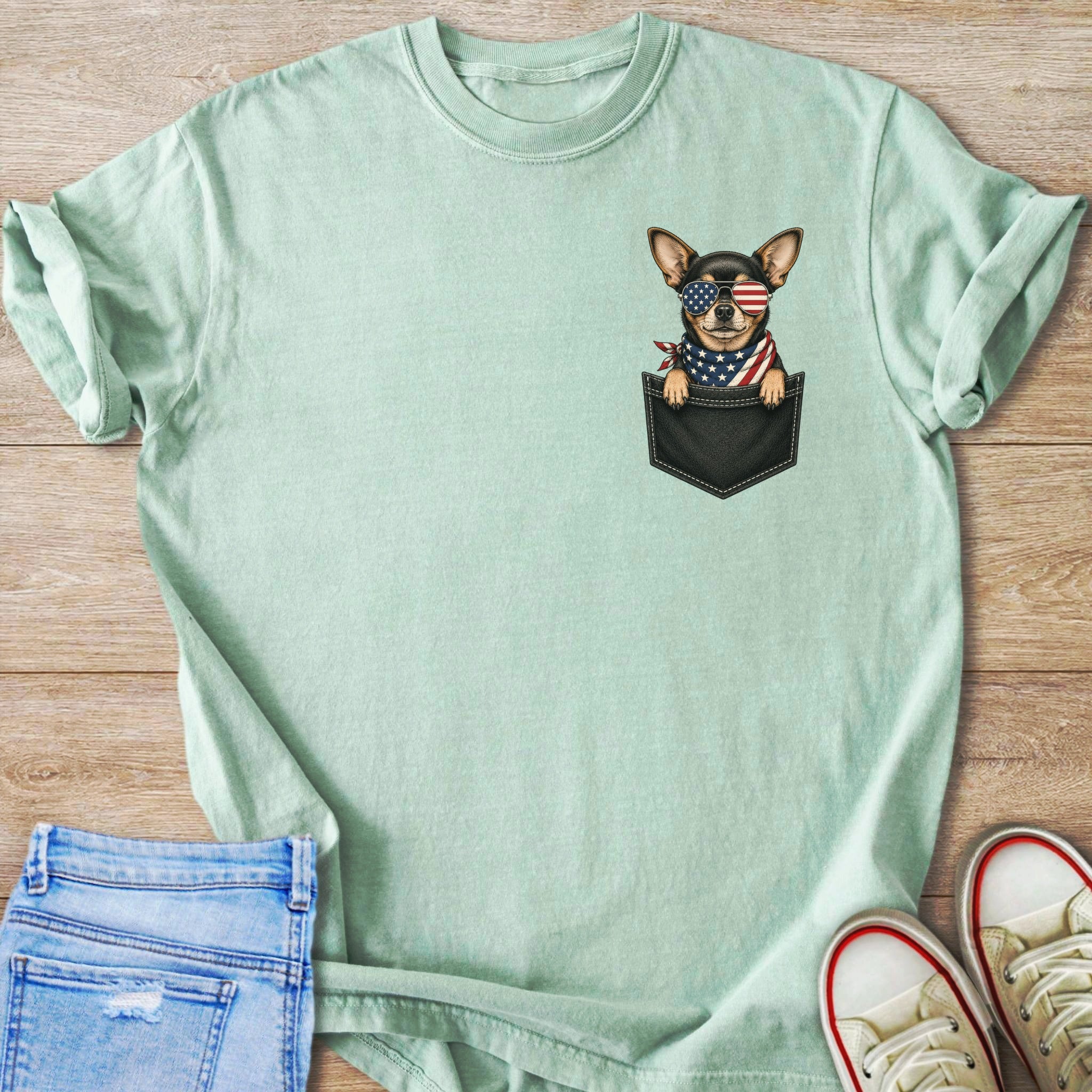 Light green t-shirt with a chihuahua wearing American flag bandana and sunglasses in a pocket.