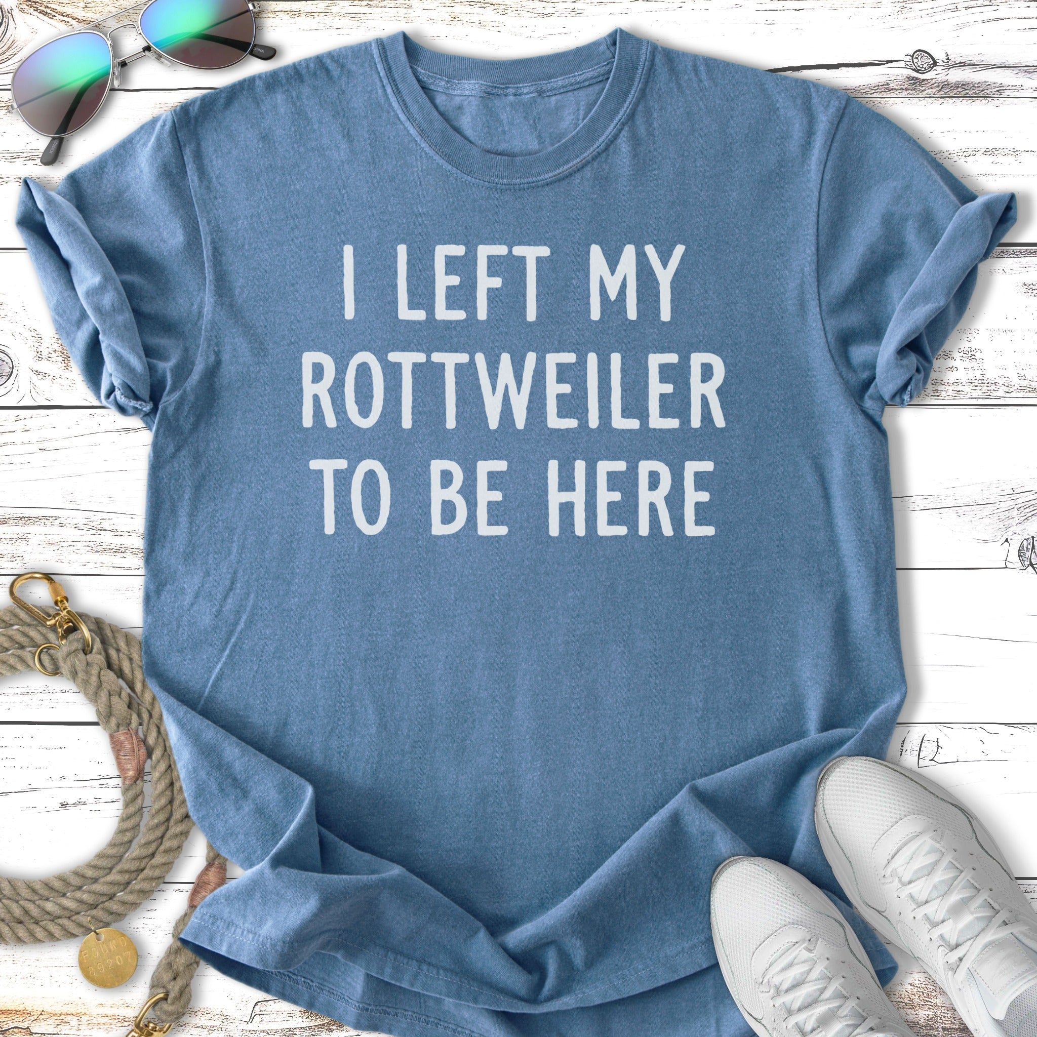 Blue t-shirt with white text "I LEFT MY ROTTWEILER TO BE HERE".