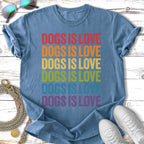 Blue t-shirt with "Dogs is Love" in rainbow colors, laying flat with sunglasses and shoes.