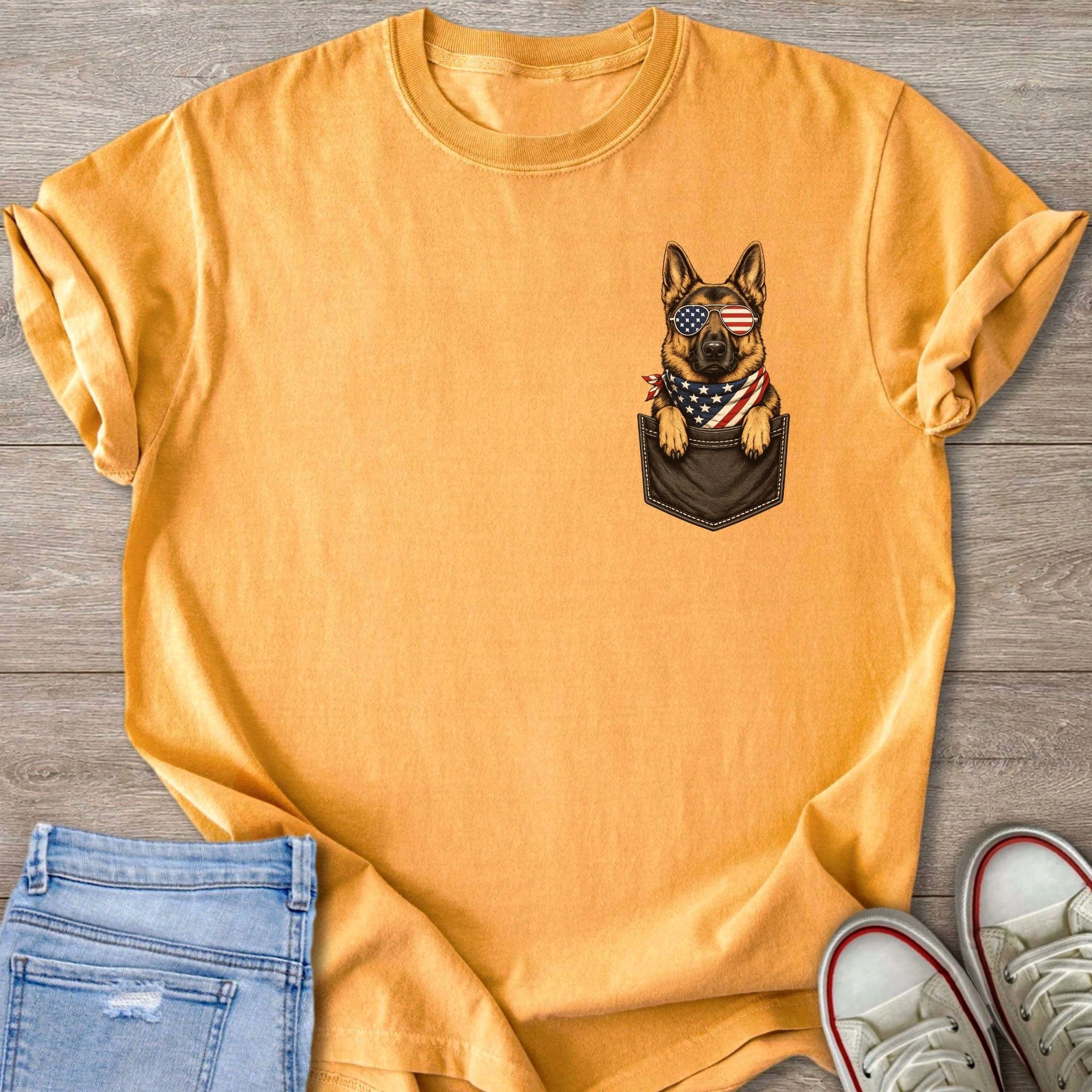 German Shepherd in pocket wearing American flag bandana and sunglasses.