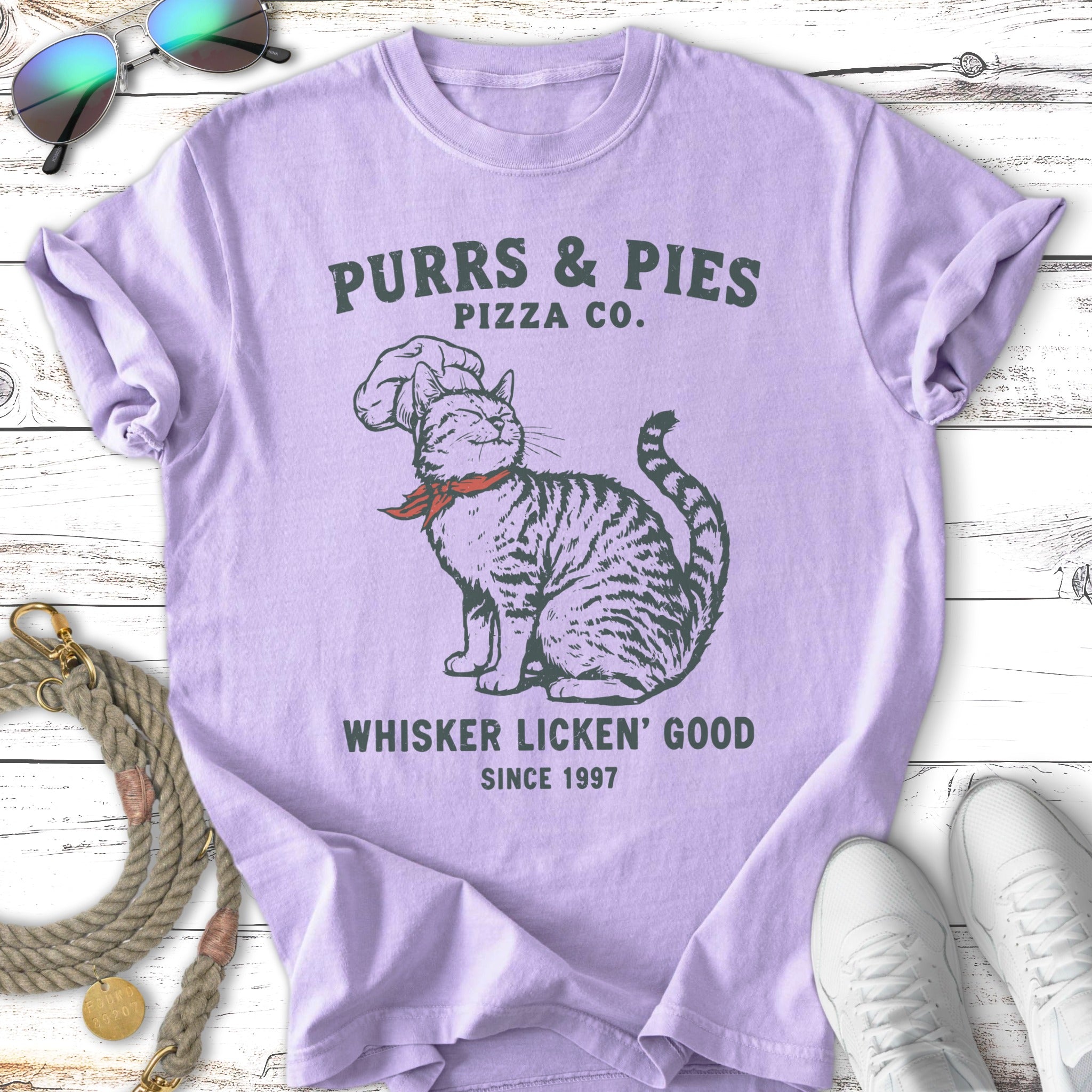 T-shirt graphic of a cat chef with "Purrs & Pies Pizza Co." text.