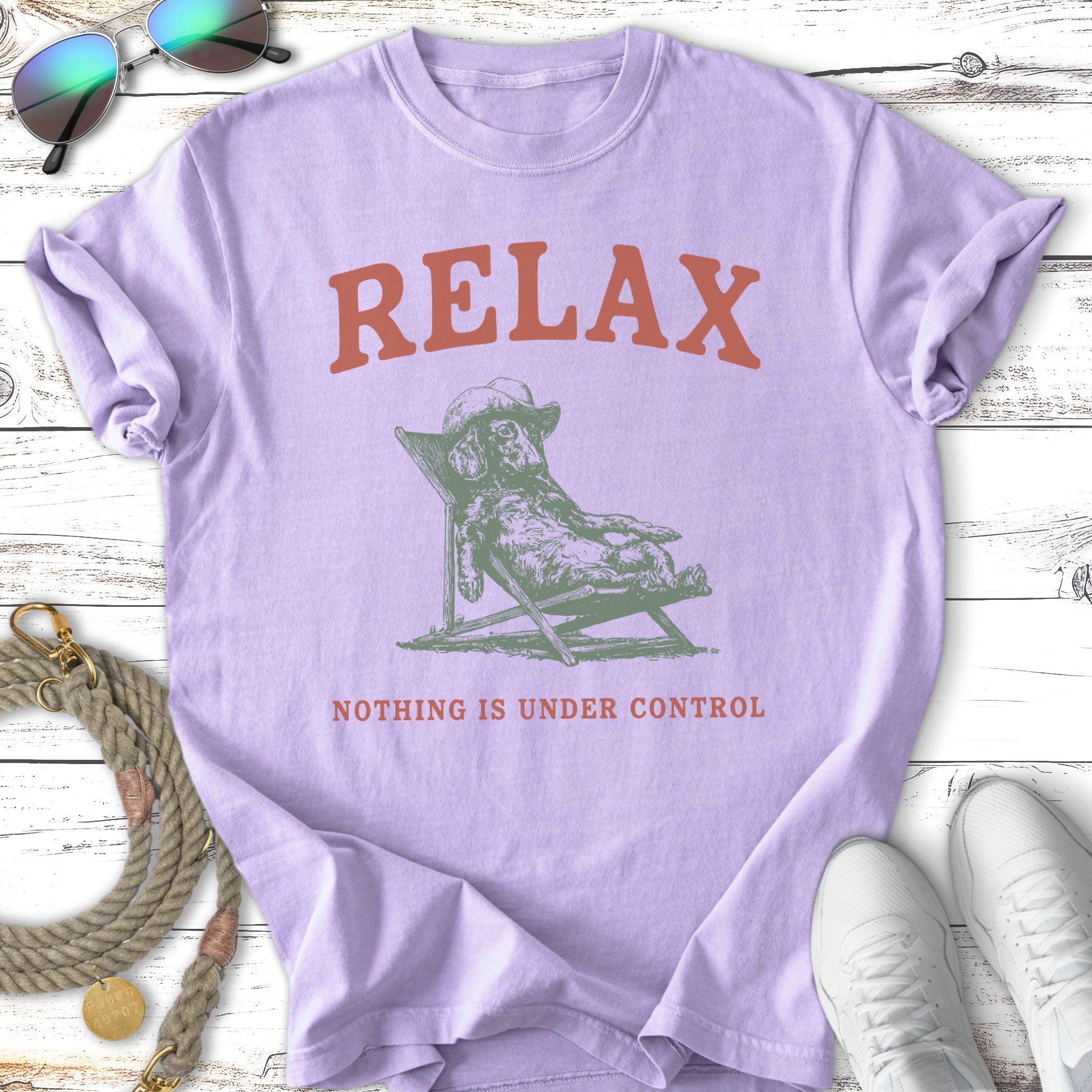 Lilac t-shirt with graphic of dog relaxing in chair, text: RELAX, NOTHING IS UNDER CONTROL.