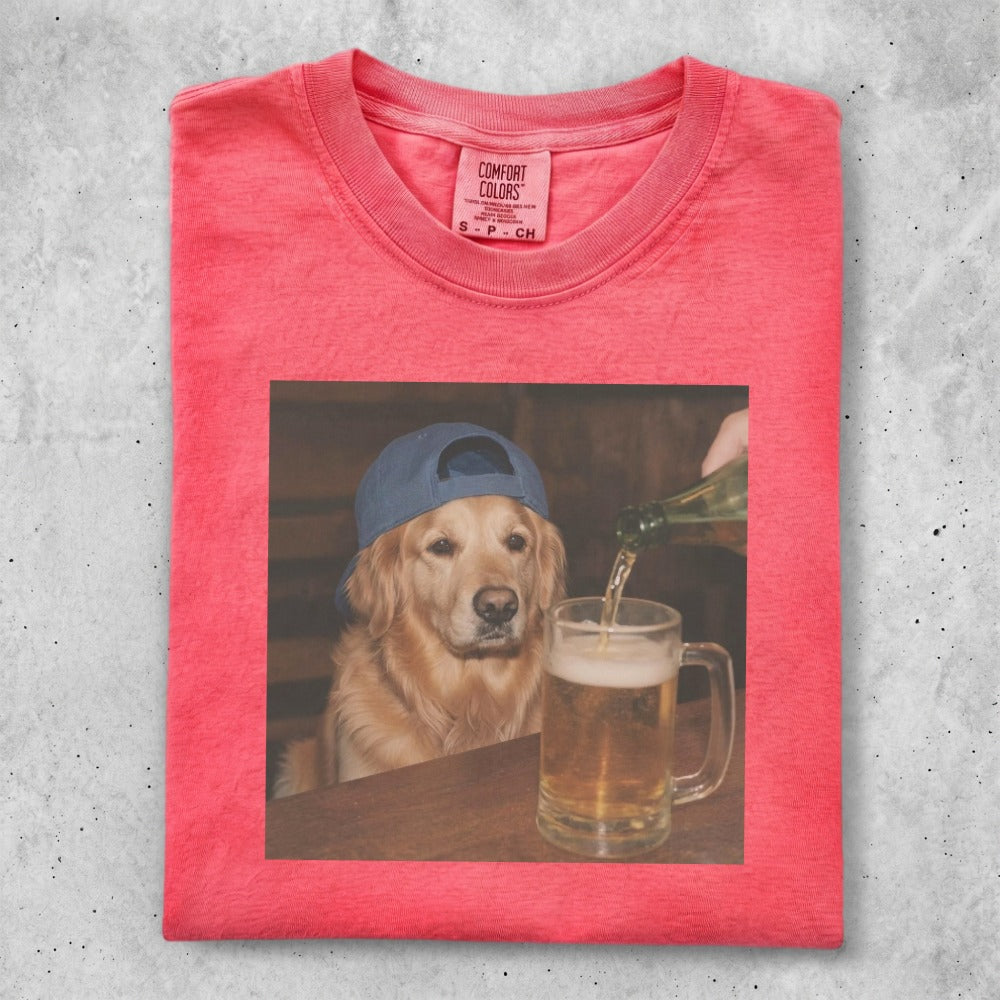 Golden retriever wearing a blue baseball cap, looking at a beer being poured.