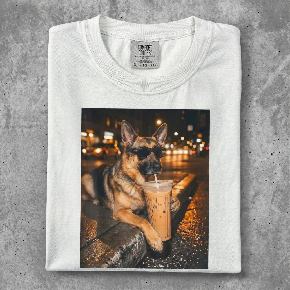 German Shepherd wearing sunglasses drinks from a coffee cup.