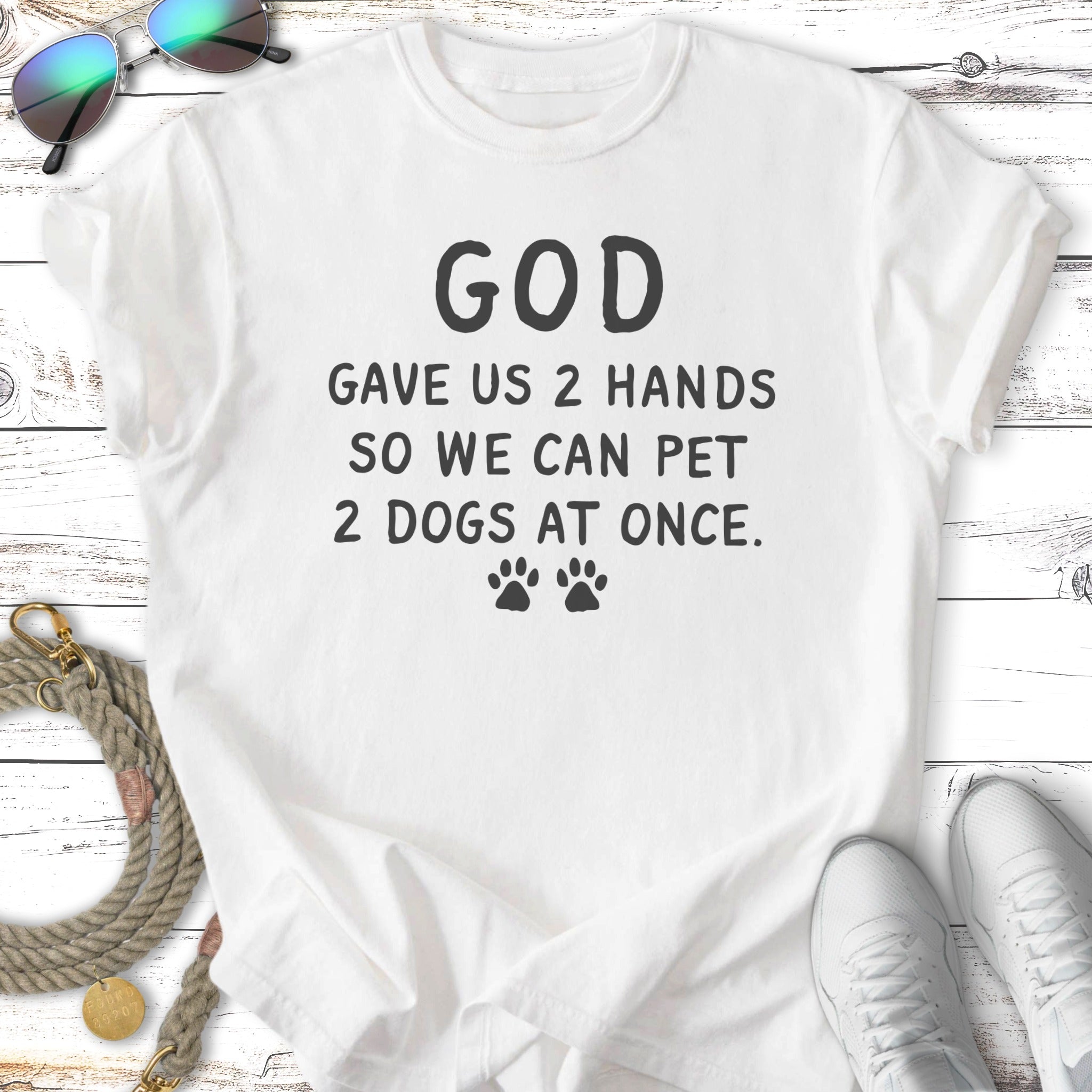 White t-shirt with "GOD GAVE US 2 HANDS SO WE CAN PET 2 DOGS AT ONCE."