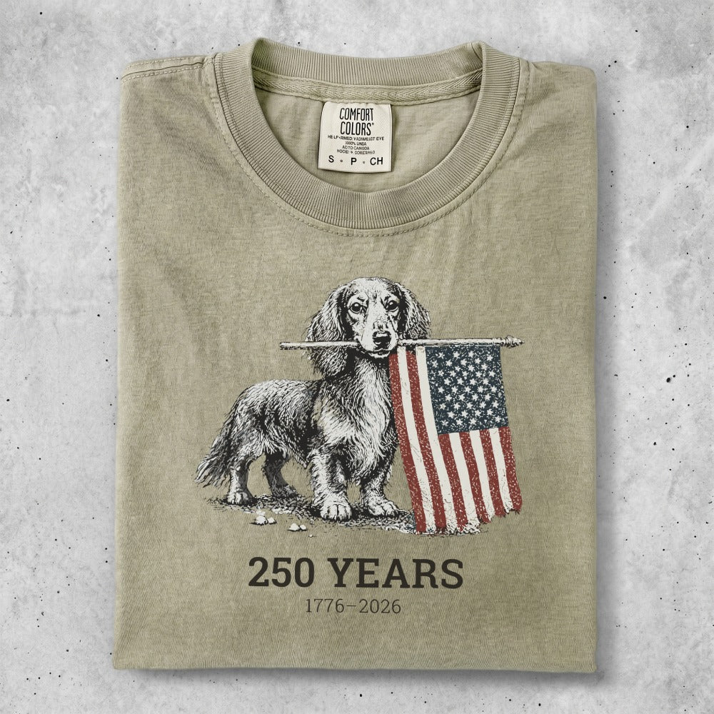 Dachshund holding American flag, "250 Years 1776-2026" text.