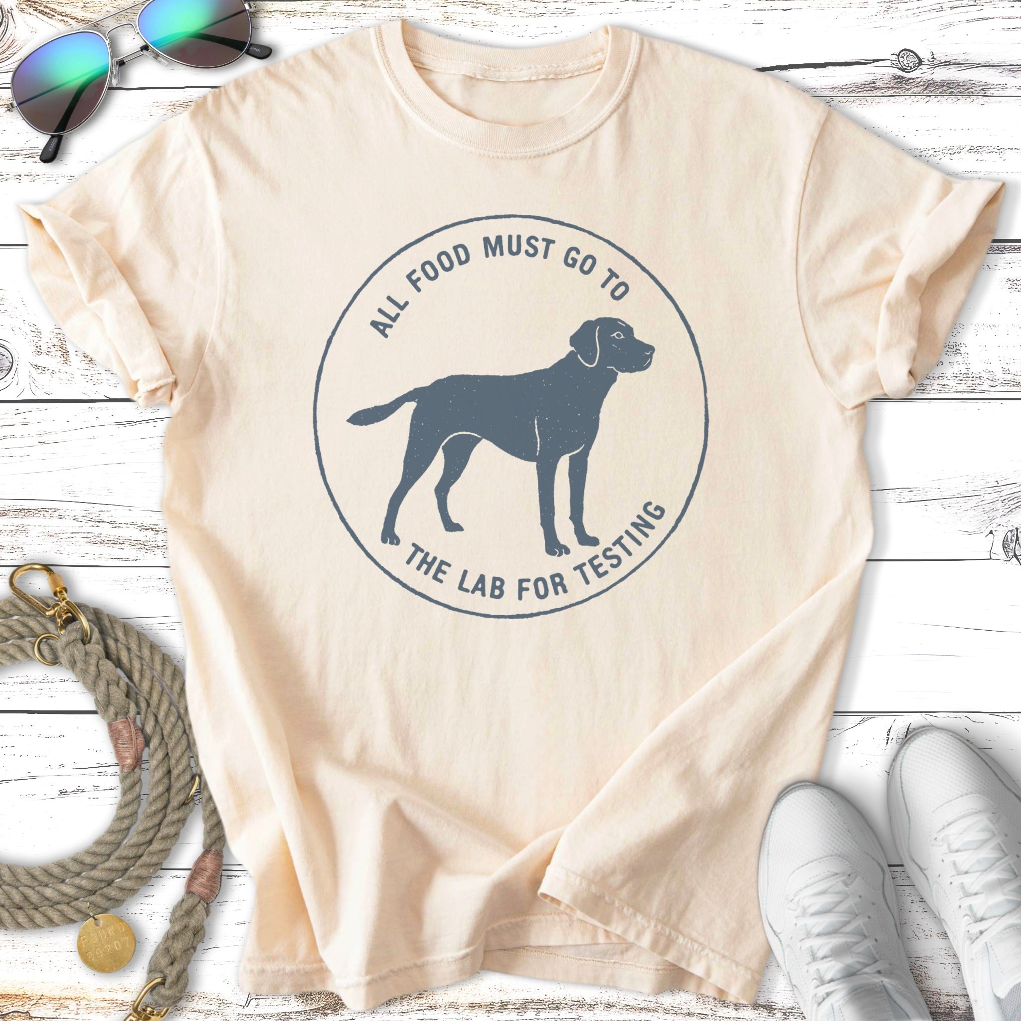 Cream t-shirt with blue graphic of dog and text "All food must go to the lab for testing."