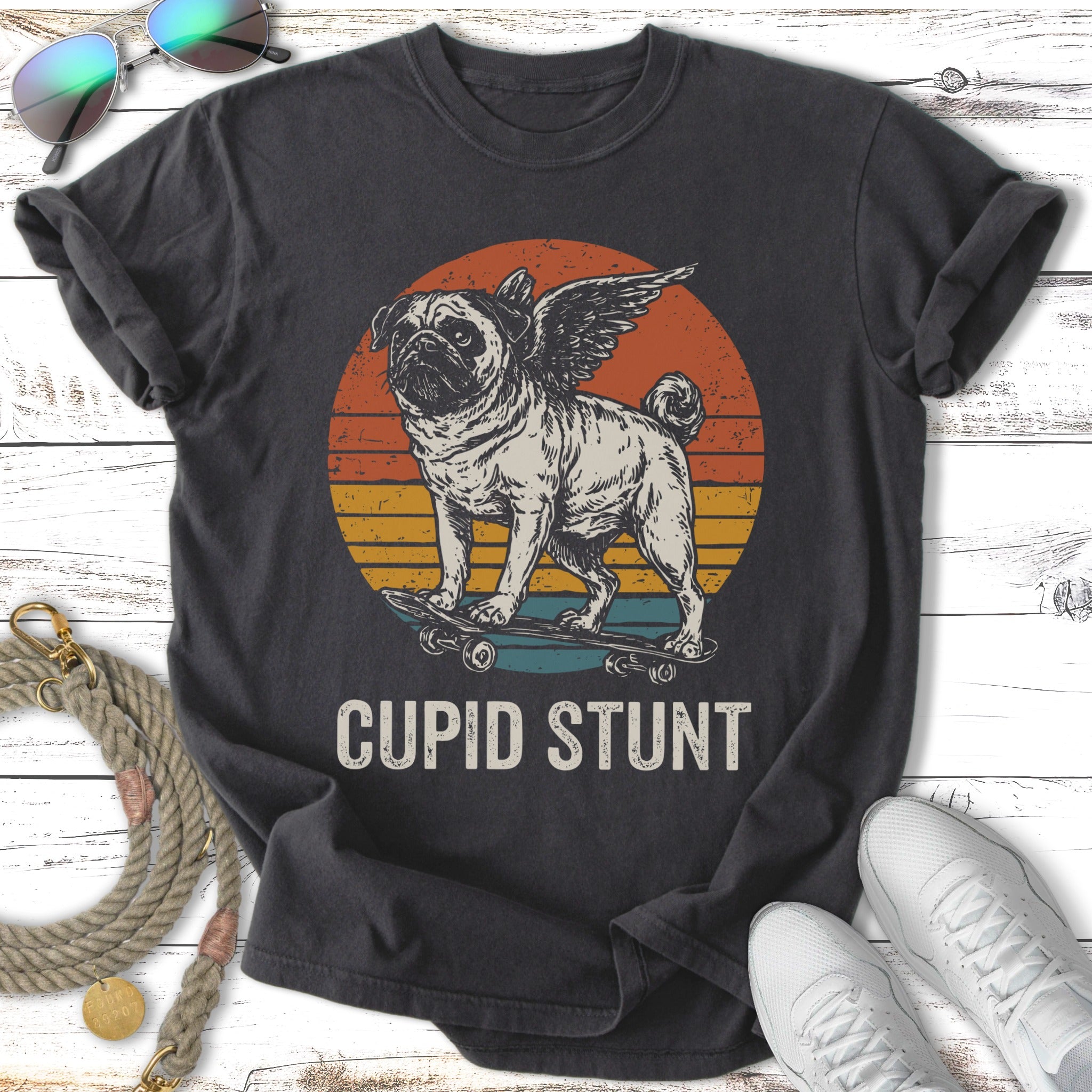 Pug with wings riding a skateboard under a sunset with text "CUPID STUNT".