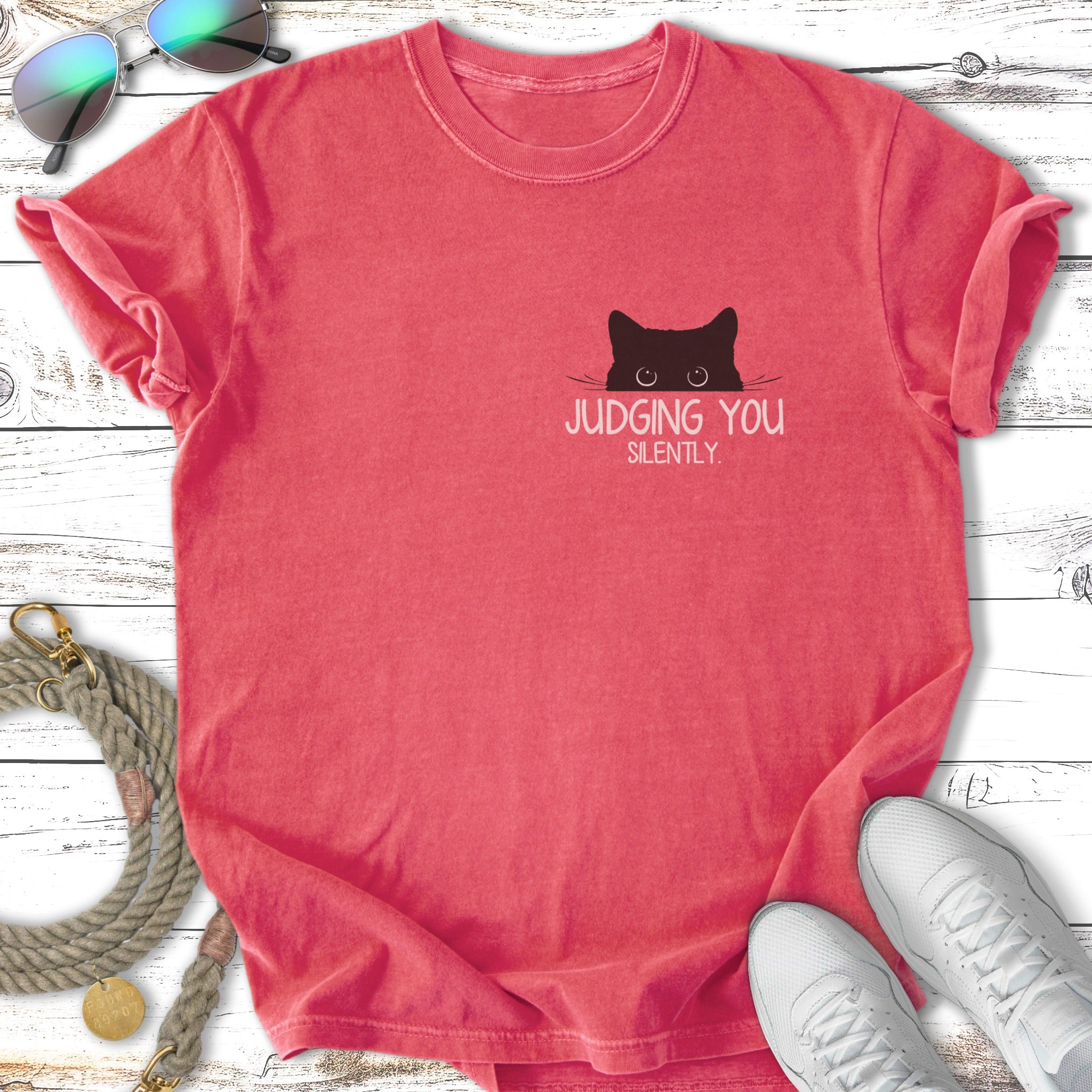 Coral t-shirt with black cat peeking over text "JUDGING YOU SILENTLY".