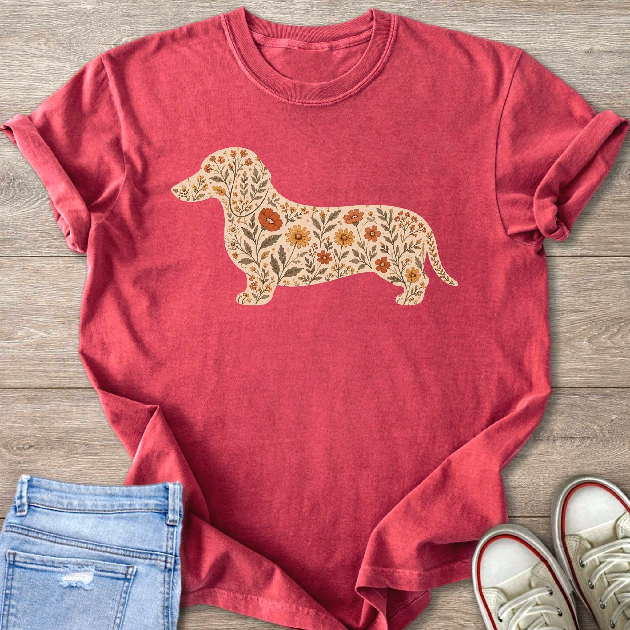 Pink t-shirt with a silhouette of a dachshund filled with an illustration of flowers and leaves.