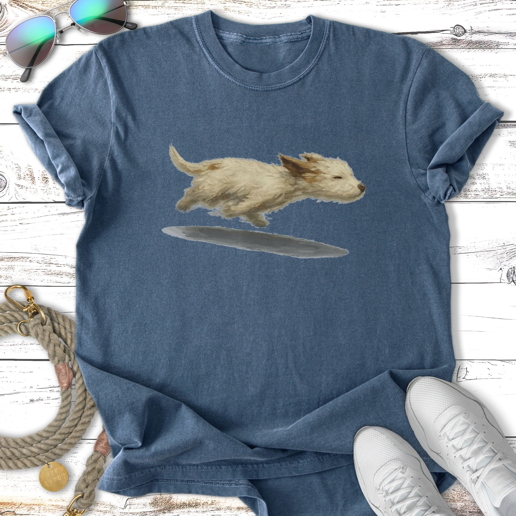T-shirt with illustration of a fluffy white dog running through water.