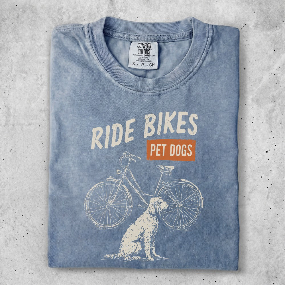 Blue t-shirt with "Ride Bikes Pet Dogs" text and a bicycle and dog graphic.