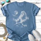 Pomeranian dog silhouette against moonlit forest landscape on t-shirt.