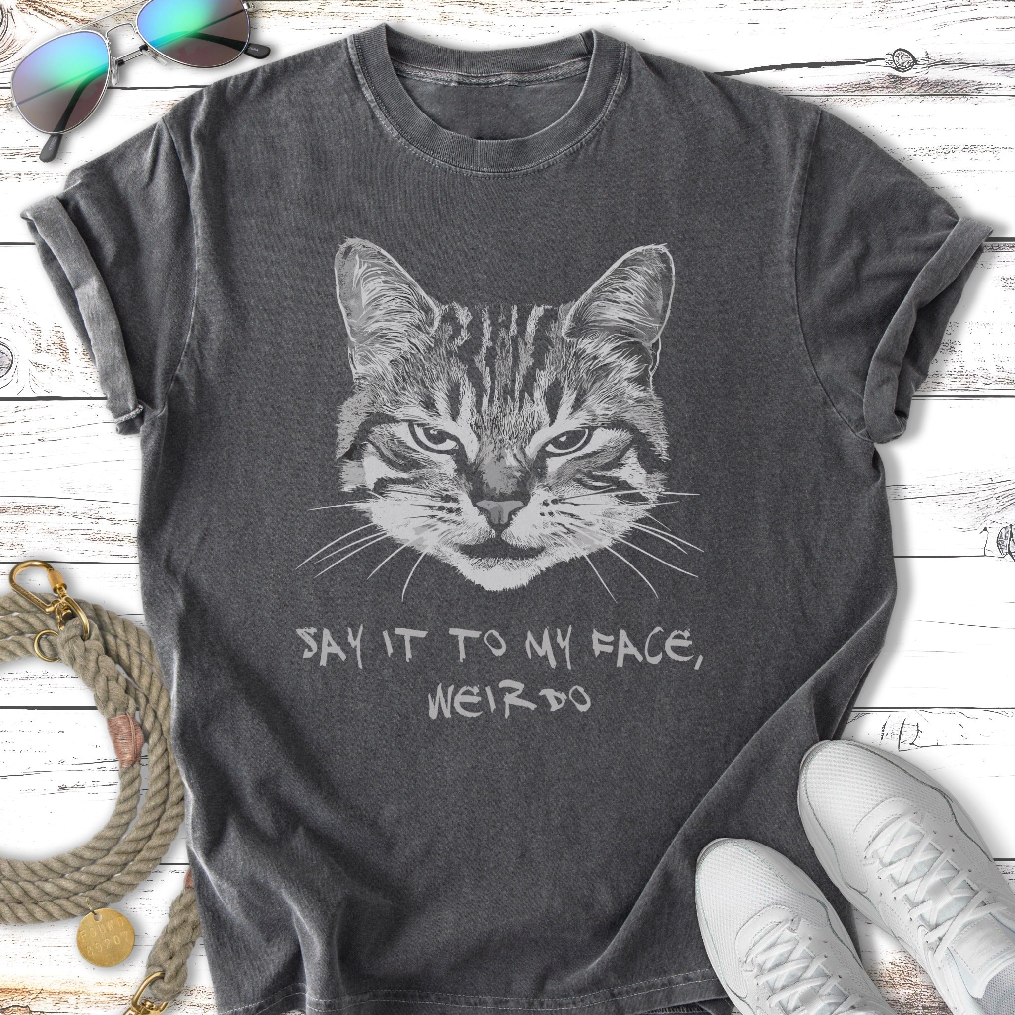 Dark gray t-shirt with a distressed cat graphic and the text "SAY IT TO MY FACE, WEIRDO".