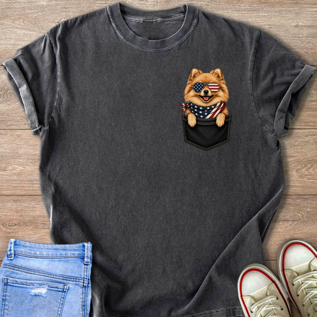 Pomeranian dog in American flag bandana and sunglasses peeking from shirt pocket.