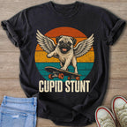 Winged pug on a skateboard with text "CUPID STUNT" and vintage sunset stripes.