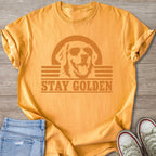 Orange t-shirt with a graphic of a dog wearing sunglasses and the text "STAY GOLDEN."