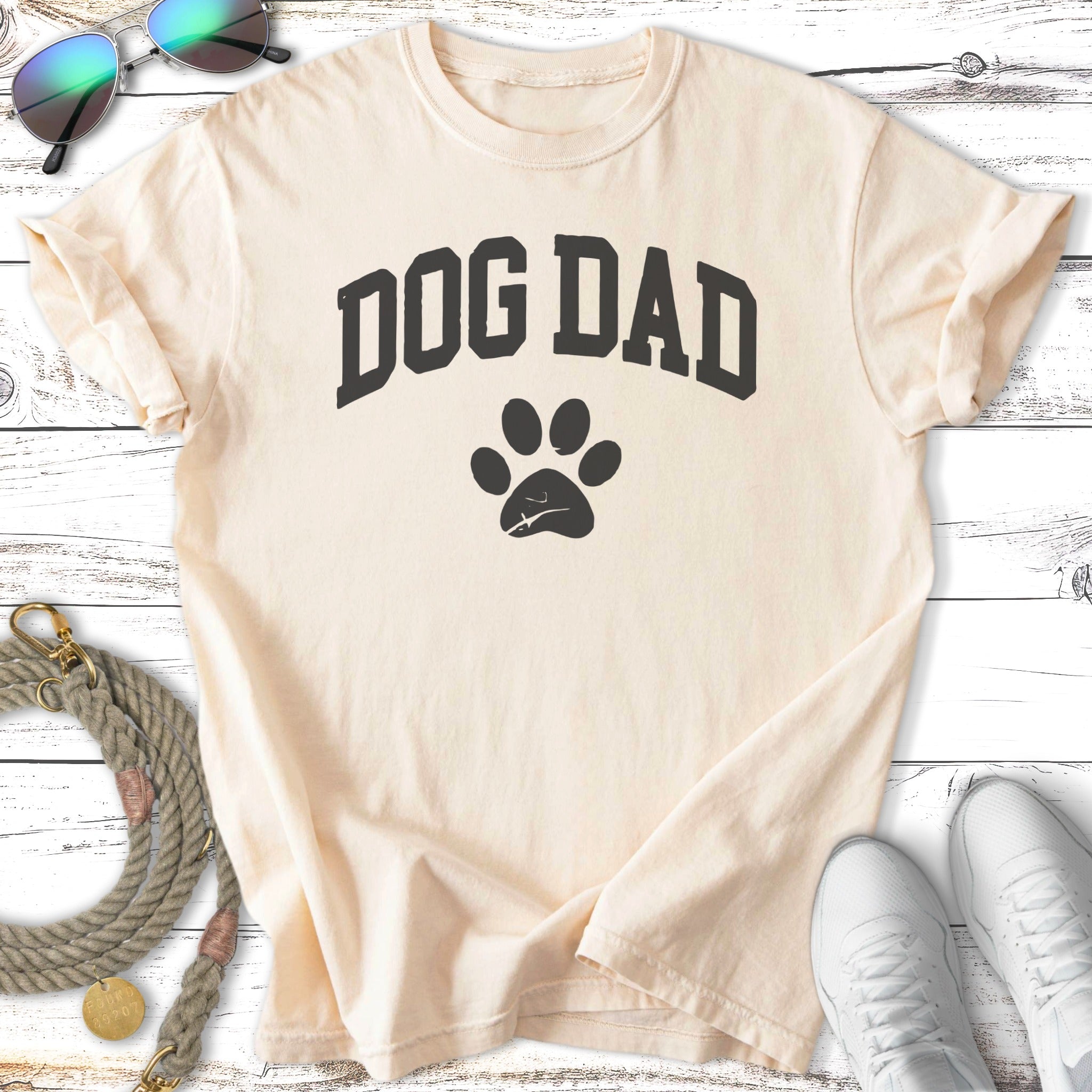Cream t-shirt with black "Dog Dad" text and a paw print.