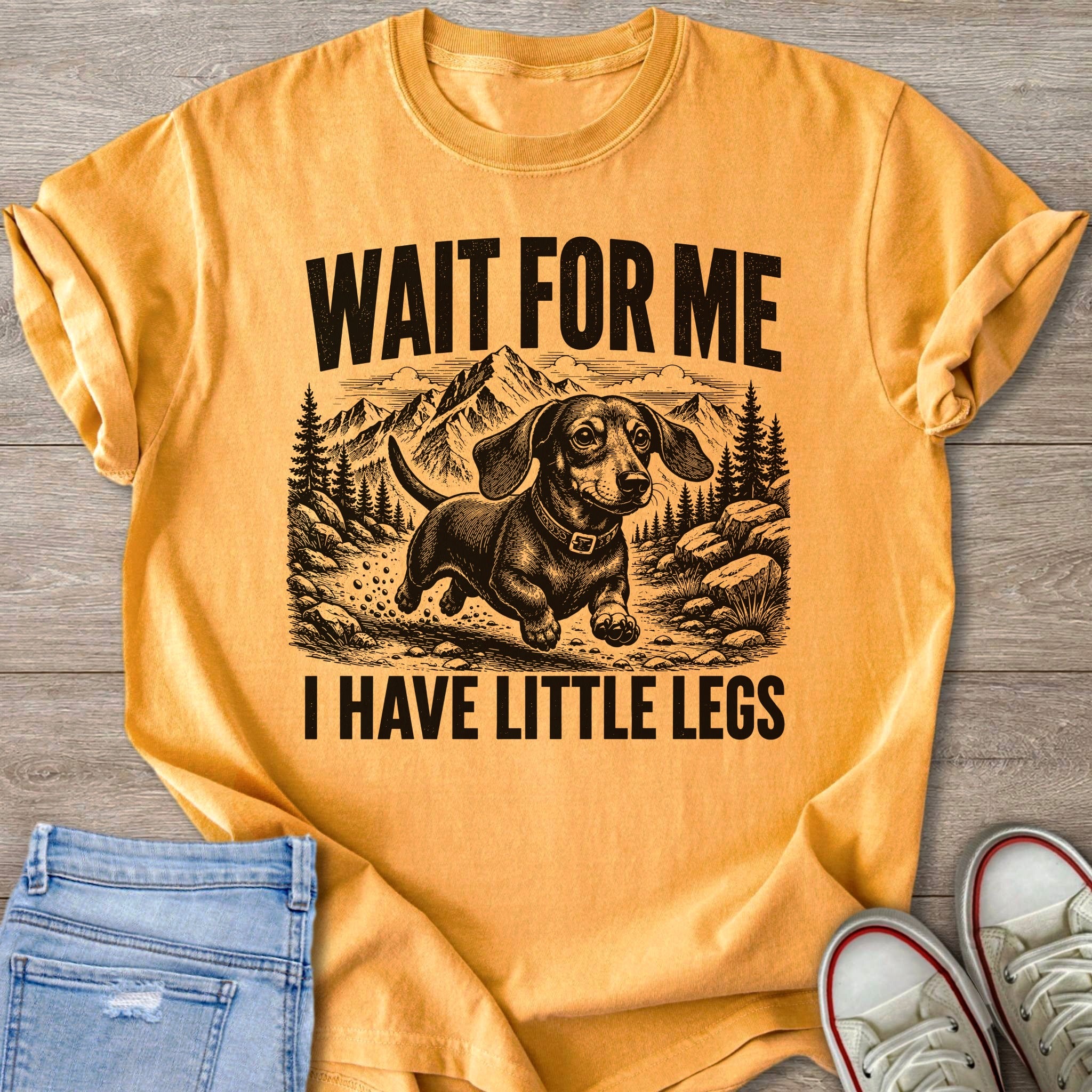 Orange t-shirt with black graphic of a dachshund and text "WAIT FOR ME I HAVE LITTLE LEGS".